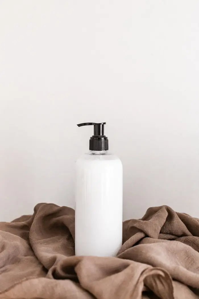A plain white bottle on a pale surface.