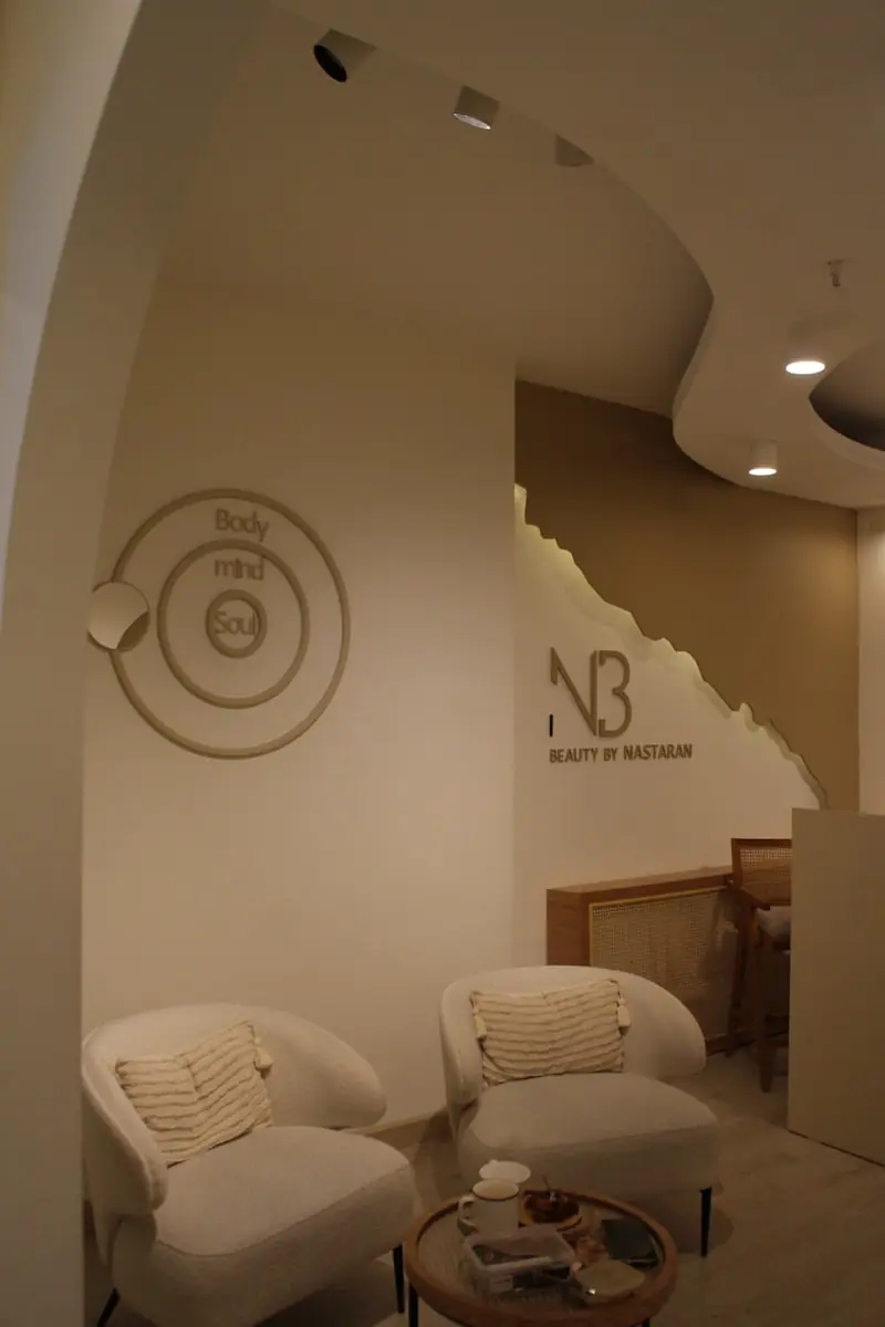 A waiting area with pale armchairs and a low table.